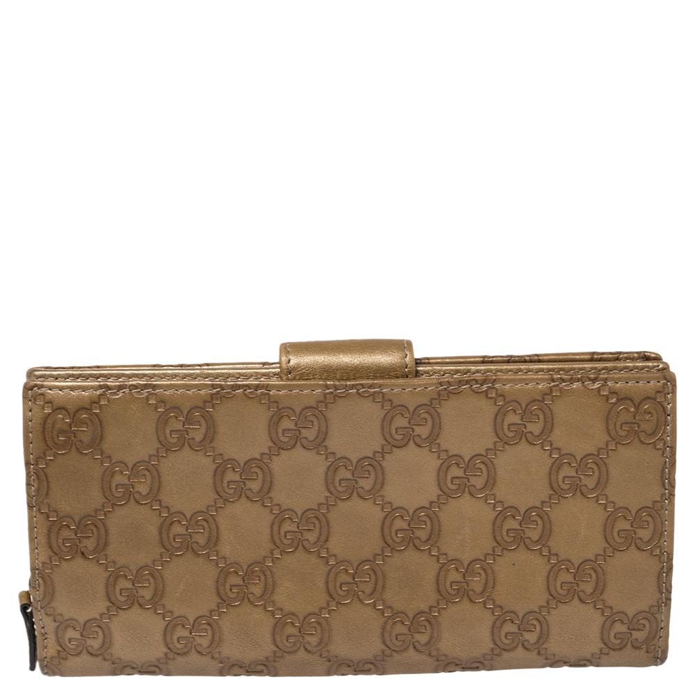 Crafted from Guccissima leather, this gorgeous wallet from Gucci carries a metallic beige exterior. The slender flap is accented with a gold-tone D-ring engraved with the brand's name that opens to a leather and fabric interior equipped with