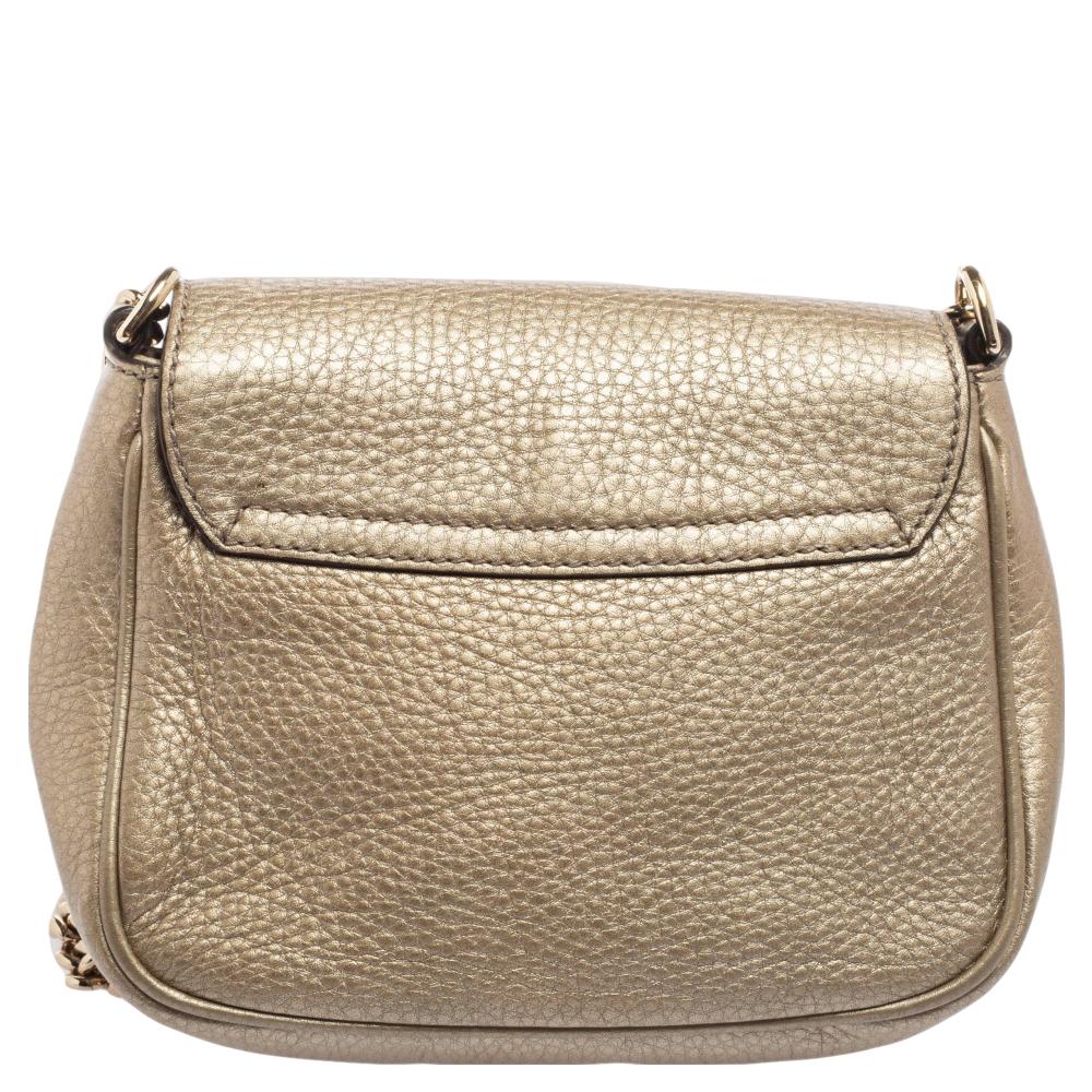 Gucci's expertise in crafting high-quality leather goods is evident through the creation of this piece. This Soho crossbody bag is designed using metallic-beige leather, with an embossed logo motif highlighting the front. It is accented with
