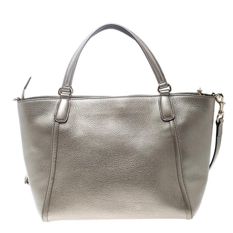 This Soho bag is one of the many designs by Gucci that is loved by women worldwide. The bag is constructed from metallic beige leather and designed with the signature GG on the front. It features a spacious canvas interior for your essentials, two
