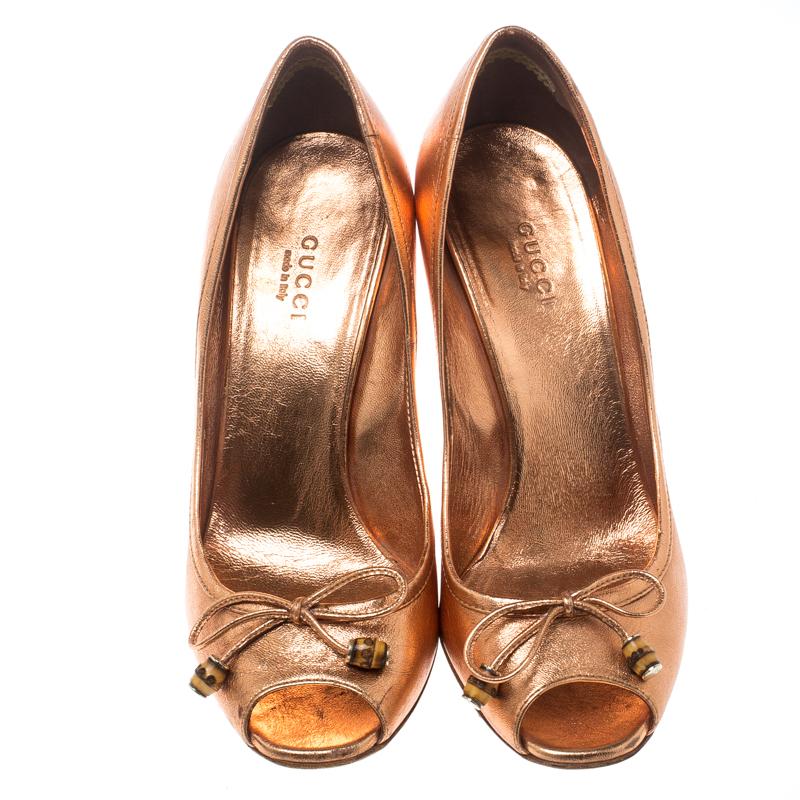 These stunning pumps from Gucci definitely need to be on your wishlist! Shining in a metallic bronze shade, these pumps are crafted from leather and feature a peep-toe silhouette. They flaunt a bow with bamboo accents on the vamps, comfortable