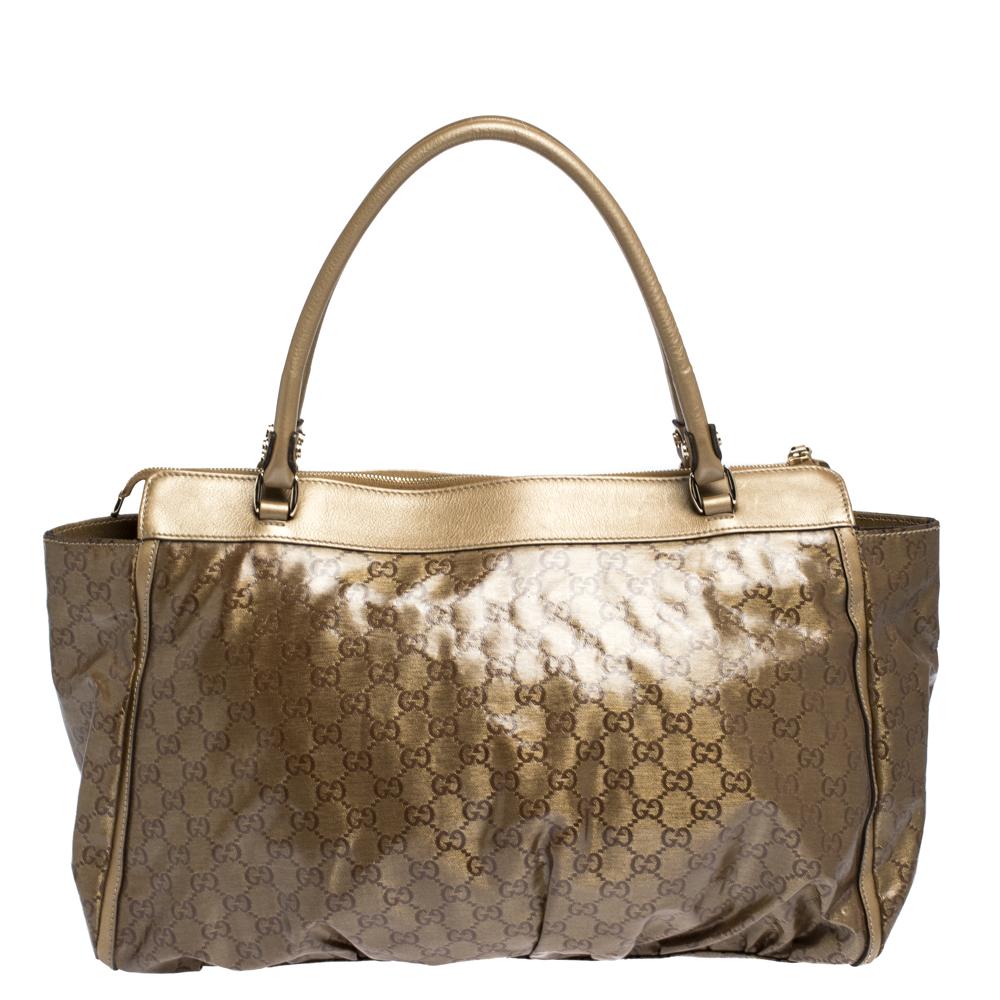 This Gucci tote bag is a must have one to be added to your collection! Made from crystal GG canvas with leather trim, it comes in lovely hues of beige and metallic. It has dual handles, D-ring, brand logo, zip closure and a spacious interior lined