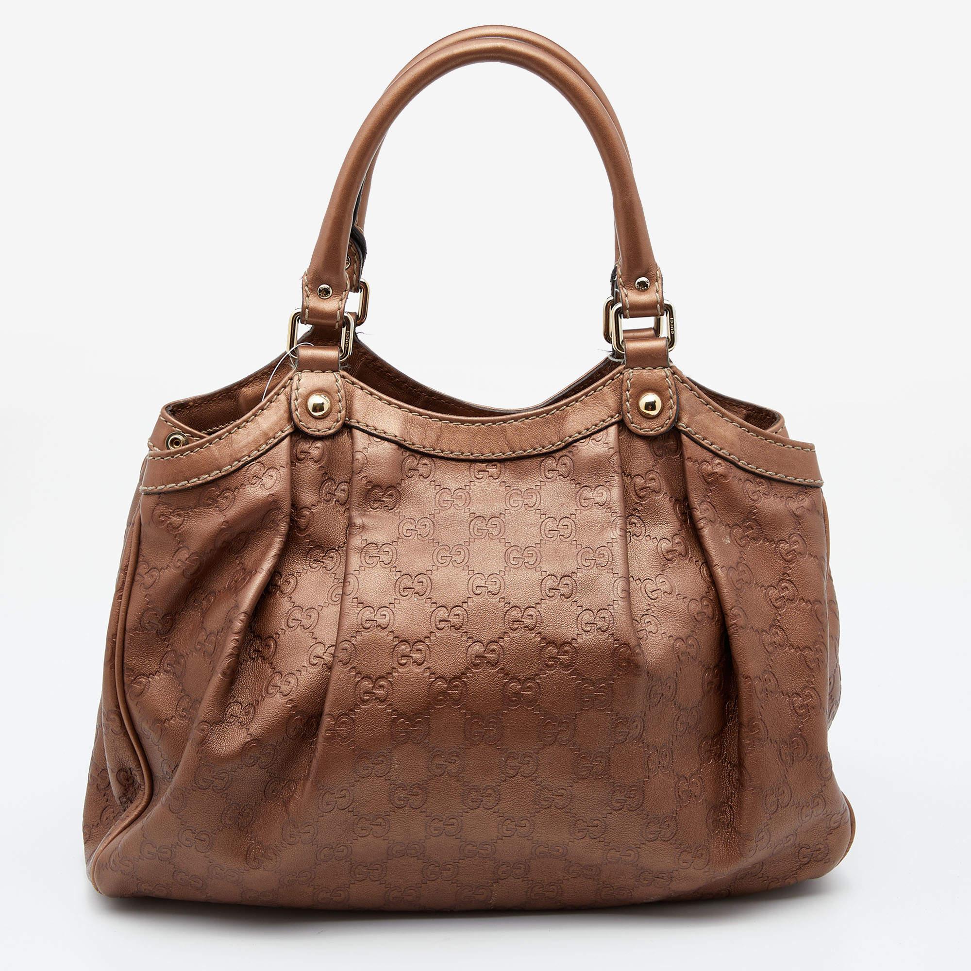 Enriched with signature details, this Sukey tote from Gucci will impress with its charming and elegant appeal. It comes crafted from Guccissima leather and flaunts dual handles, a branded charm, and neat pleats. Lined with fabric, its spacious