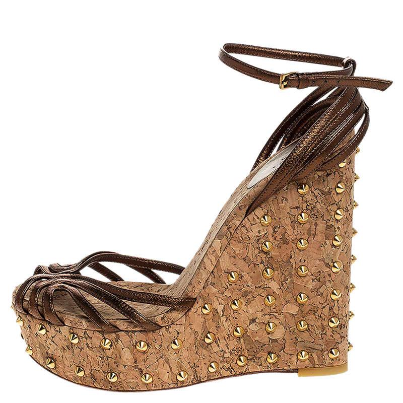 These sandals from Gucci have been designed to lift your style. They flaunt metallic brown leather straps to secure your feet perfectly and are elevated on studded cork wedge heels. Pair them with a dress for a fashionable brunch outing and get set