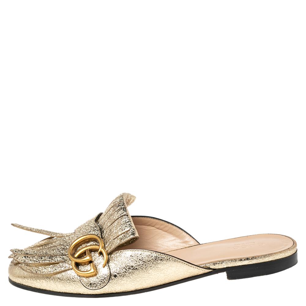 Absolutely on-trend and easy to flaunt, this pair of mules by Gucci is a true stunner. The metallic gold mules have been crafted from crinkled leather and styled with folded fringes and the brand's signature GG on the uppers. Comfortable insoles