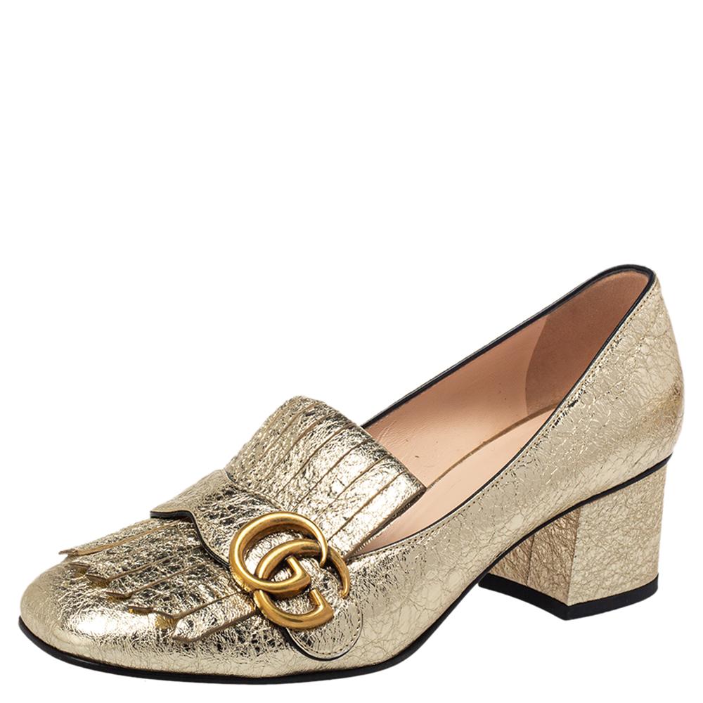 Dieses Paar Pumps von Gucci liegt voll im Trend und ist ein echter Hingucker. Sie wurden aus goldfarbenem Metallic-Folienleder gefertigt und mit gefalteten Fransen und dem markentypischen GG auf dem Obermaterial gestylt. Quadratische Zehen und ein