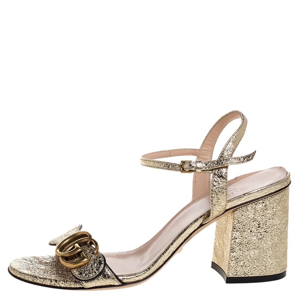 How gorgeous are these GG Marmont sandals from Gucci! Crafted in Italy, they are made from foil leather and adorned in a metallic gold shade. They are styled with open toes, GG logo on the vamp straps, buckled ankle straps, low block heels, and