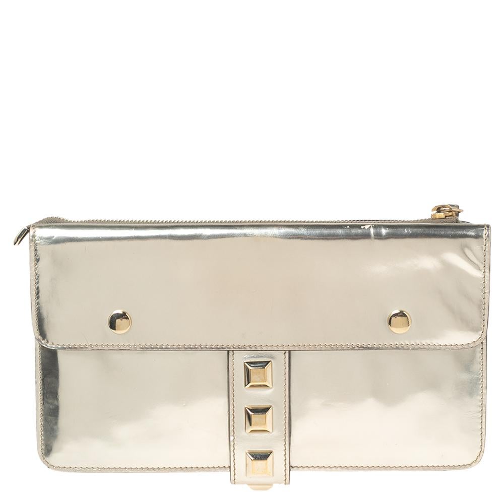 Flaunt this stunning yet practical wristlet clutch from Gucci at the next party! It has a dazzling metallic gold, laminated leather body that is highlighted with gold-tone studs. It comes with a smooth fabric interior to hold your essentials.

