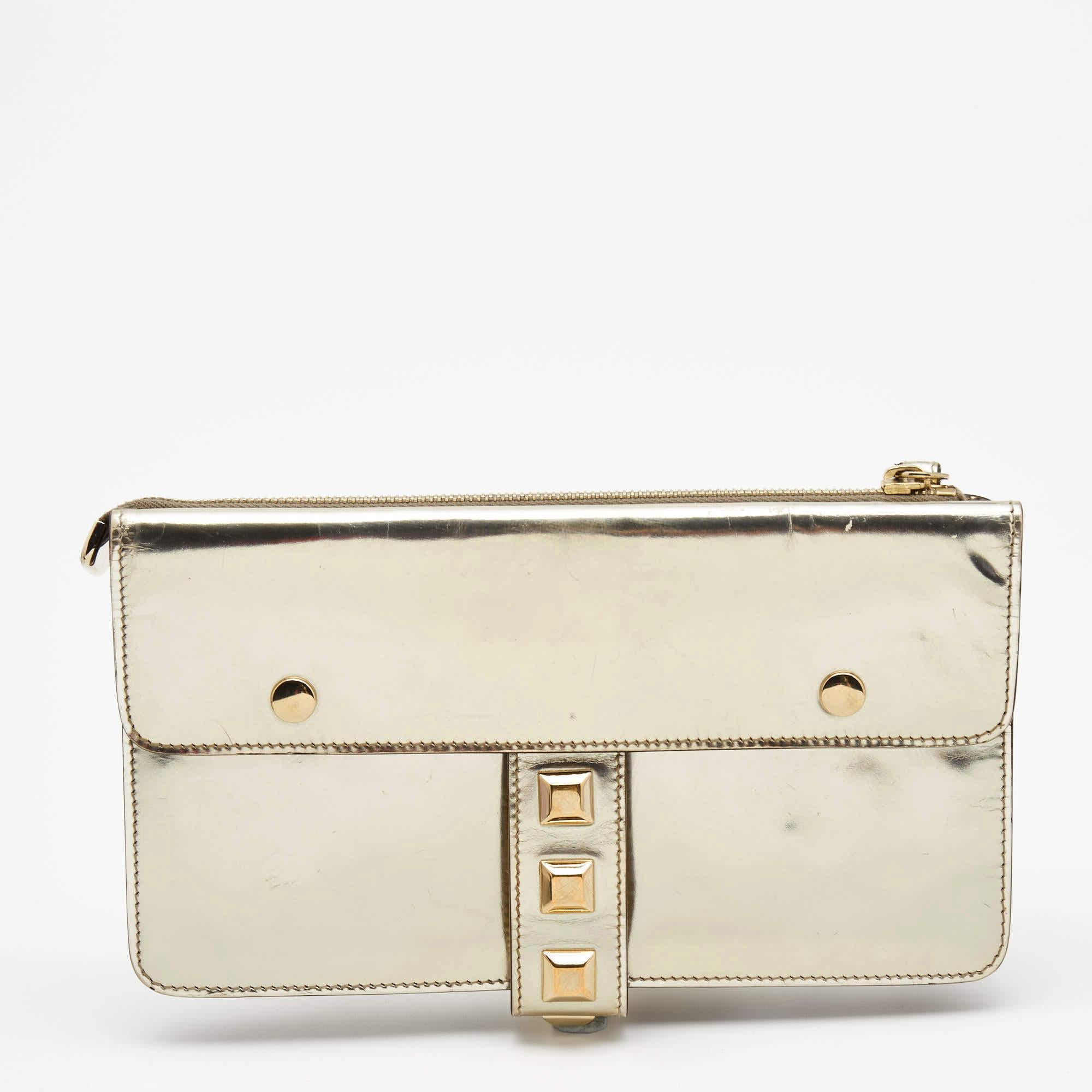 Flaunt this stunning yet practical wristlet clutch from Gucci at the next party! It has a dazzling metallic gold, laminated leather body that is highlighted with gold-tone studs. It comes with a smooth fabric interior to hold your essentials.

