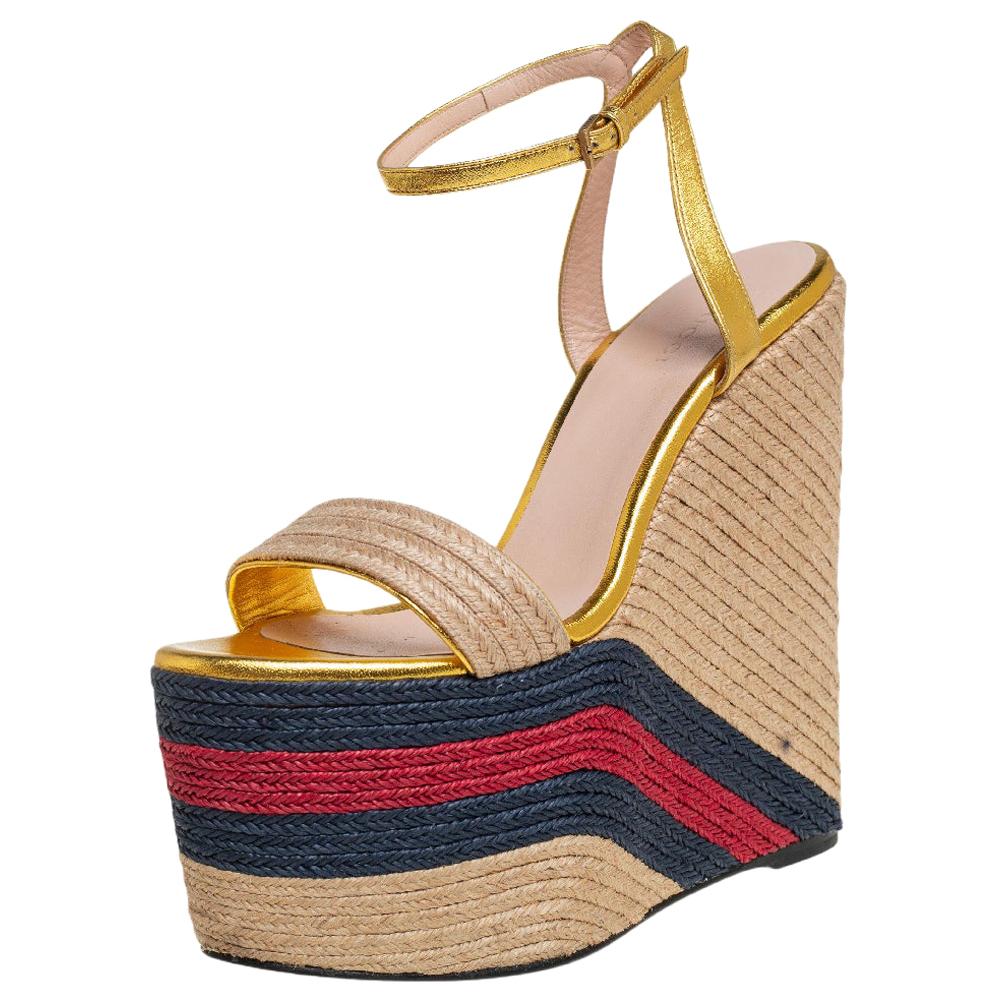 Gucci's opulent aesthetic and stellar craftsmanship in shoemaking is evident in these stunning espadrille sandals. Crafted from leather in a gold shade, these sandals are adorned with chunky platforms covered with jute and elevated by the signature