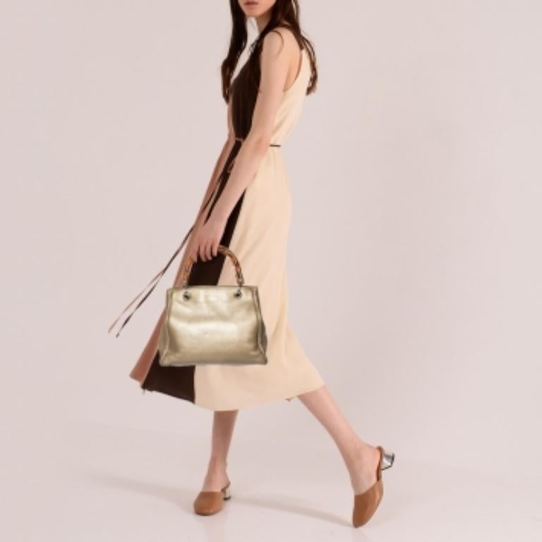 Handbags as fabulous as this one are hard to come by. So, own this gorgeous Gucci tote today and light up your closet! Crafted from metallic gold leather, this stunning number has a spacious canvas interior and is wonderfully held by two bamboo