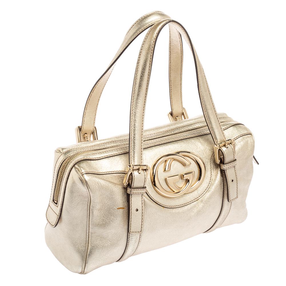Des détails simples, une haute qualité et une commodité quotidienne caractérisent ce Britt Boston de Gucci. Le sac est réalisé en cuir doré métallisé et présente des poignées doubles, un logo GG de couleur dorée sur le devant et un intérieur