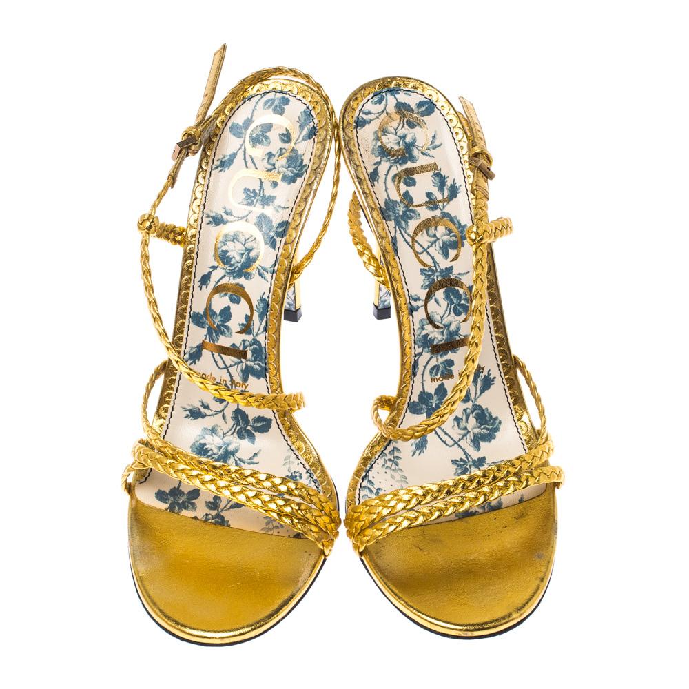 Beauty flows out of these sandals from Gucci! Crafted from metallic gold leather, these sandals are enchanting. They feature a design of braided straps across the toes and as slingbacks. The sandals are complete with floral-printed soles and 10.5 cm