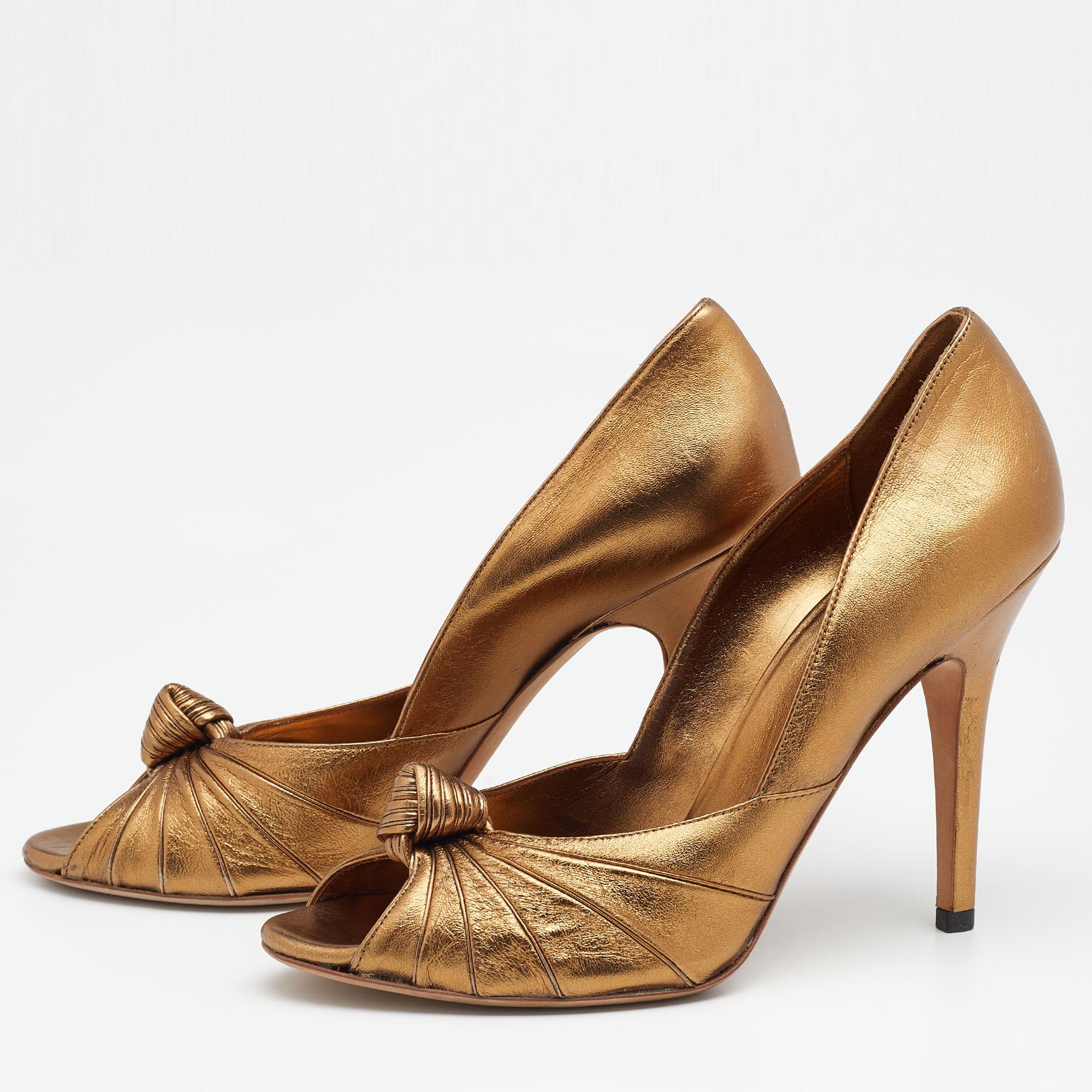 The 11.5cm heels of this pair of Gucci pumps will reflect grace and elegance in every step. Created from gold leather, it is made attractive with a knotted design on the vamps and flaunts a slip-on fitting.

Includes: Original Dustbag, Original Box,