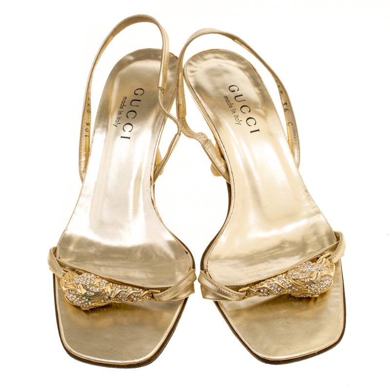 Coming from the house of Gucci, these sandals feature a metallic gold leather body perfect for evening occasions. They are set on low block heels and come accented with crystal and metal embellishments on the vamps. They feature slingback straps and