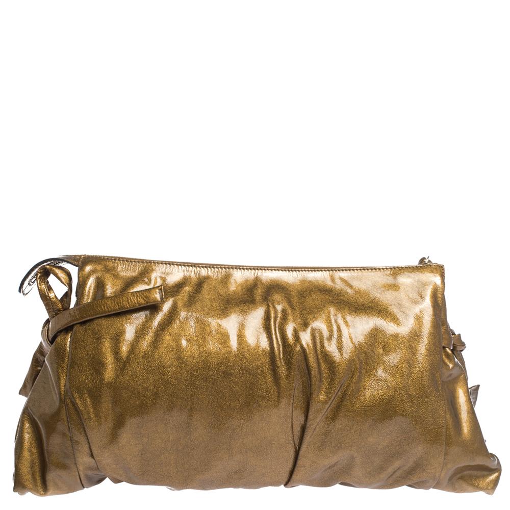 This Gucci clutch is built to suit all your stylish ensembles. Crafted from patent leather, it has a metallic gold shade and a zipper which secures a nylon-lined interior. The clutch is complete with the signature Hysteria emblem on the front and a