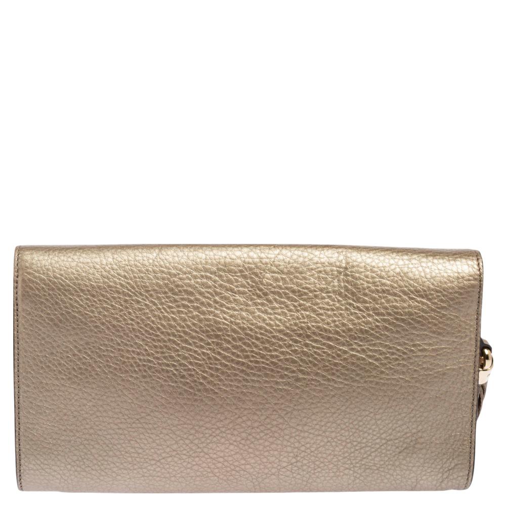Fancy clutches are a wardrobe must-have. Made in Italy, this Soho clutch by Gucci has been crafted out of gold pebbled leather, lined with canvas on the insides, and sized to fit in your essentials. It has gold-tone hardware, a flap closure, a