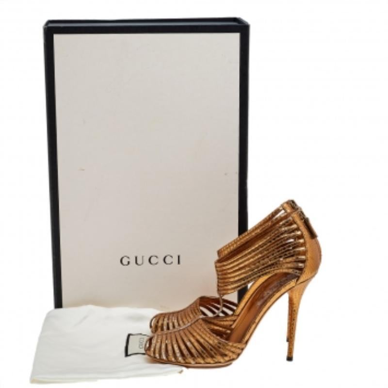 Designed exceptionally, these stunning sandals from Gucci will right complement your feet. They are crafted using metallic gold python leather on the exterior and are accentuated by strappy details, a T-strap, and zipped counters. They are completed
