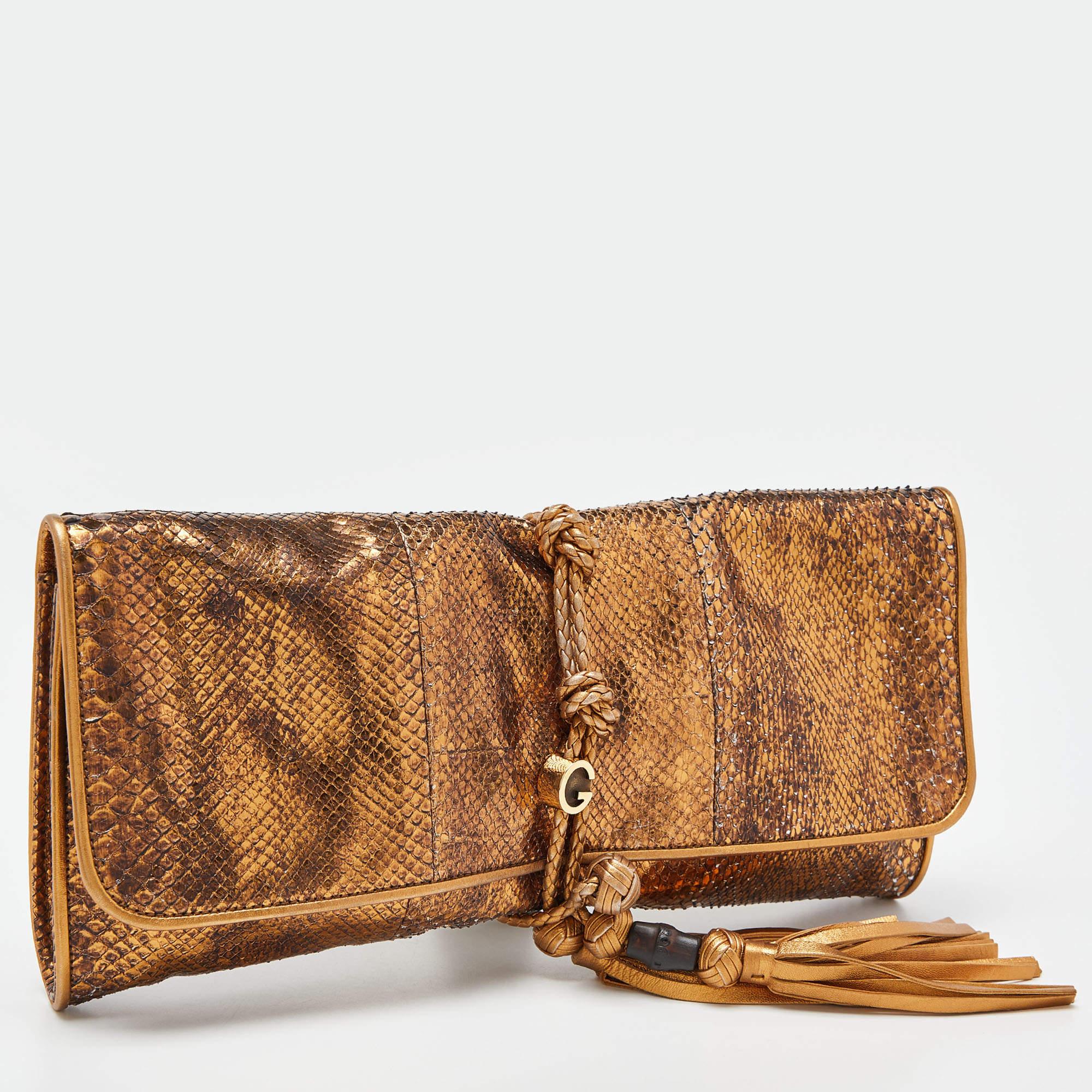Just right for conveniently storing your valuables without weighing your look down, this Gucci clutch features a python leather exterior with braided strings and a bamboo accent. Carry it in hand as a stylish evening accessory.

