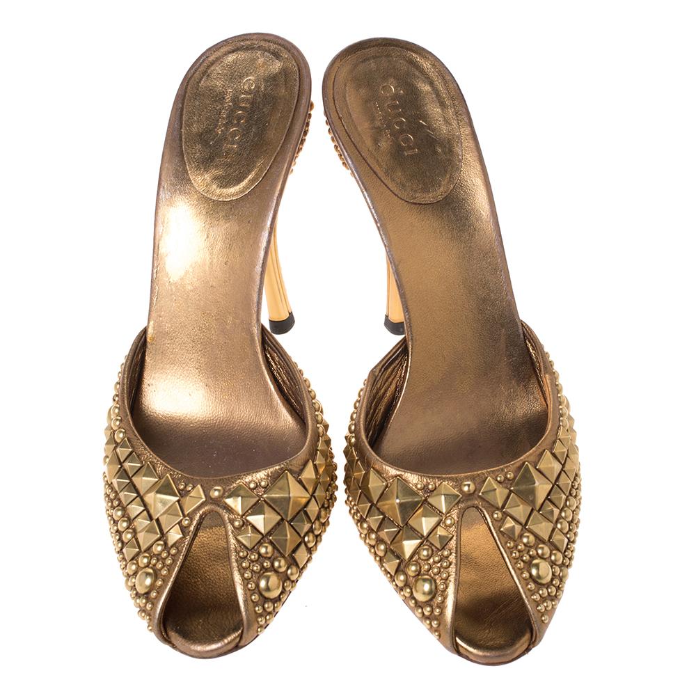 These sandals by Gucci are perfect for a special occasion. They are crafted meticulously and made from quality leather. They come in a lovely shade of metallic gold. They are styled with peep toes, stud detailing, gold-tone hardware and 10.5 cm