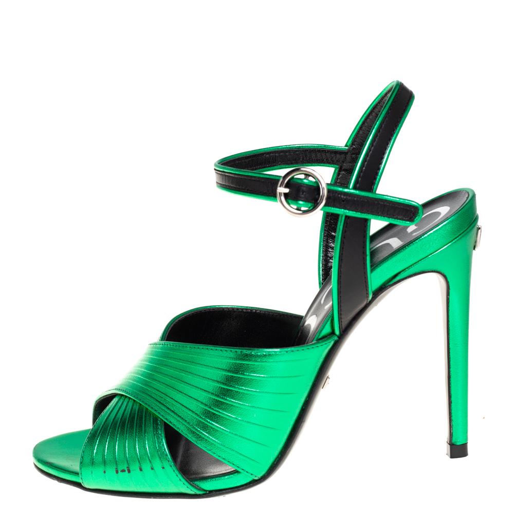 Beauty radiates from these sandals from Gucci! Crafted from metallic green leather, these sandals have cross vamp straps, ankle straps with buckle fastening, and 10 cm heels to lift you elegantly. The sandals come in Gucci's new eco-friendly