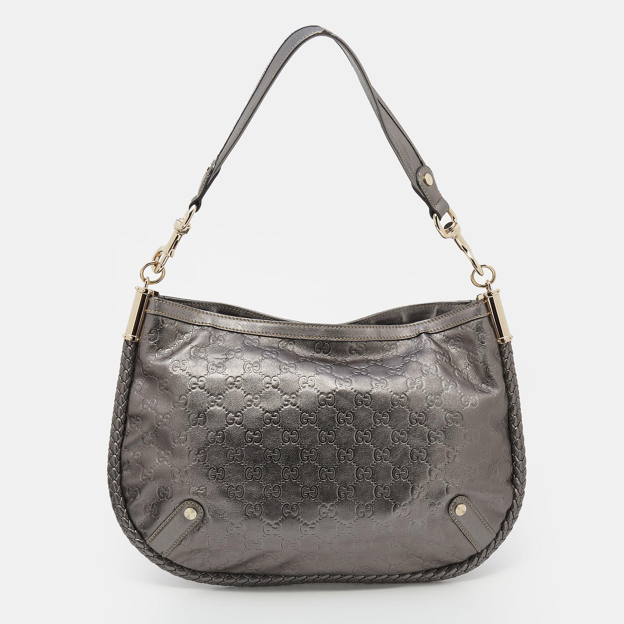 This Britt bag from the House of Gucci is both elegant and fashionable. Crafted from metallic-grey Guccissima leather, this bag features a shoulder strap, gold-tone hardware, and a fabric-lined interior. A logo accent is placed on the front. Make