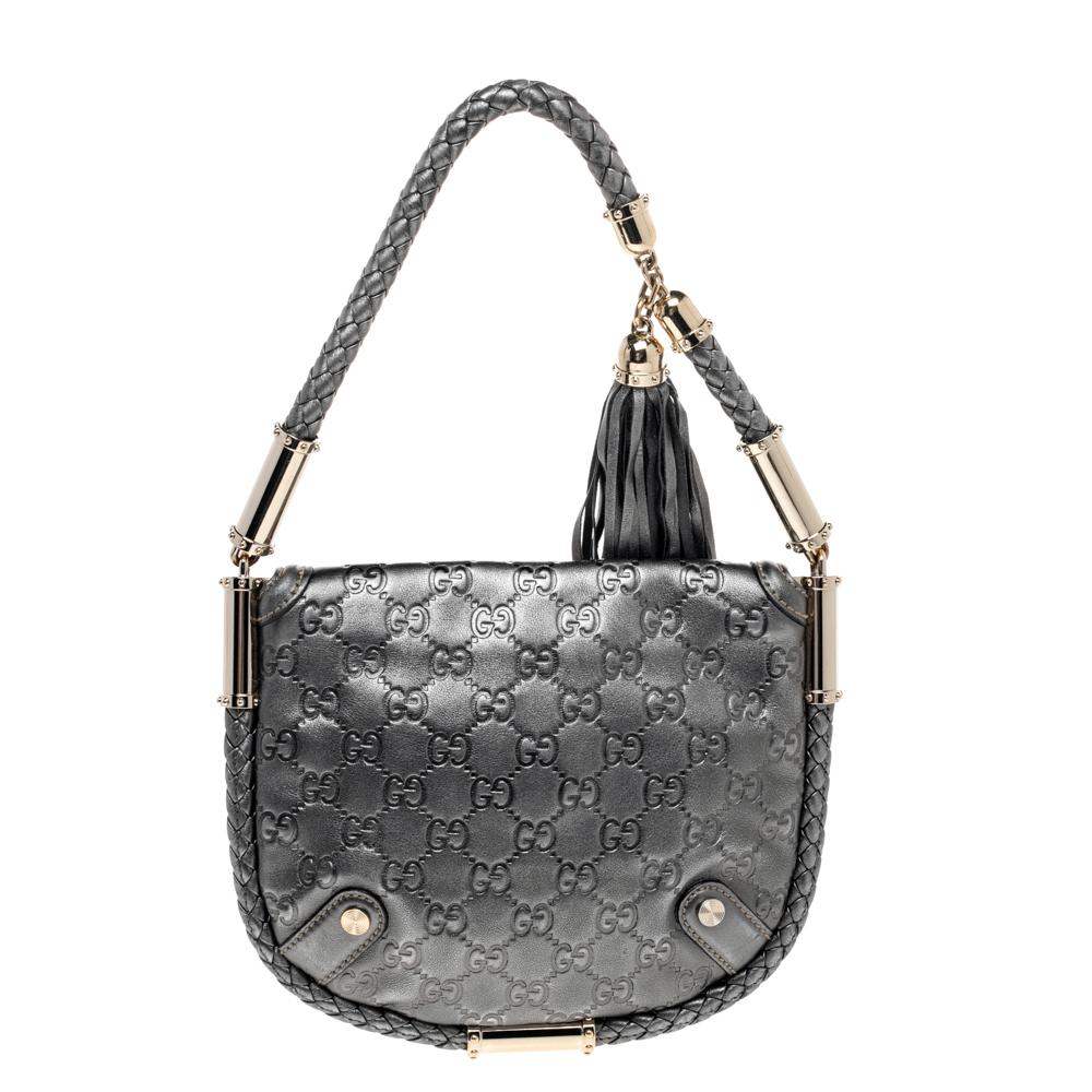 A glossy companion for your outings, this wondrous Britt hobo by Gucci is one of its kind. It has been crafted in metallic grey leather. The exterior features a braided trim extending to form a shoulder strap with fringed tassel and gold-tone