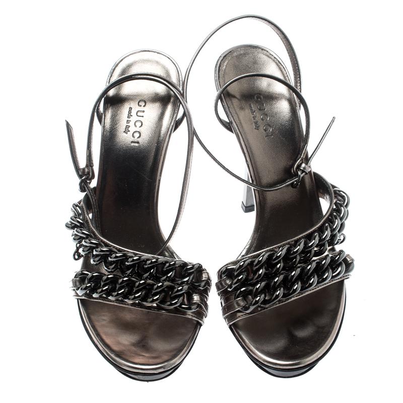Make the streets your fashion runway and walk in style in these fabulous sandals from Gucci! These metallic grey sandals have been crafted from leather and styled in an open toe silhouette. They flaunt GG chain detail on the vamp straps and come
