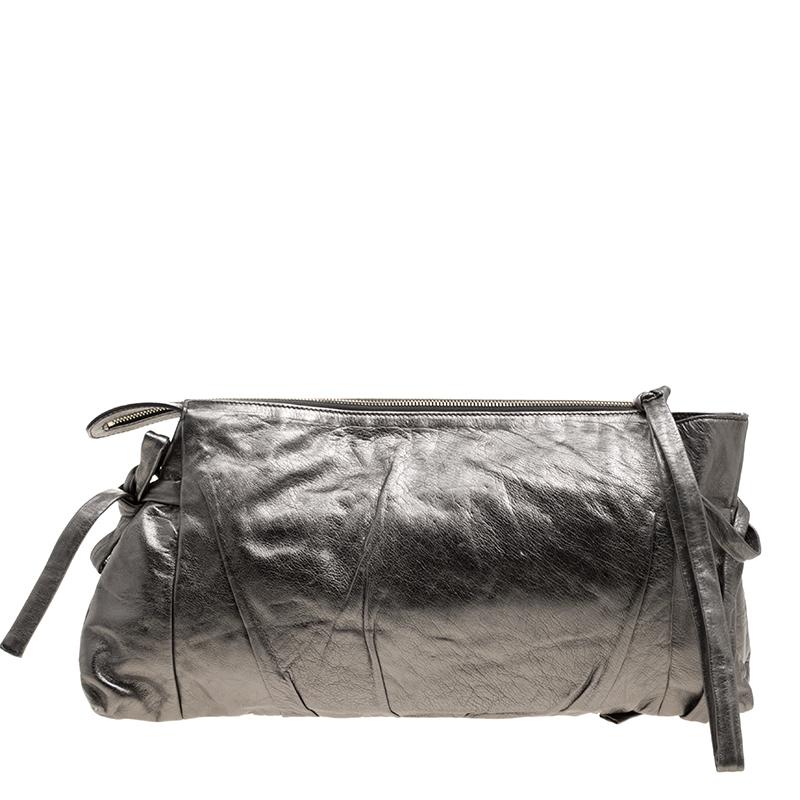 This Gucci clutch is built to suit your stylish ensembles. Crafted from leather, it has a metallic grey shade and a zipper which secures a nylon interior. The clutch is complete with the signature Hysteria emblem on the front and a