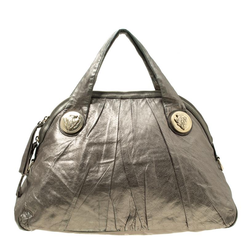 This Gucci Hysteria handle bag is ideal for everyday wear as well as evening outings. Its metallic grey leather exterior is easy to match with any outfit, and the gold-tone Hysteria motifs give it a signature touch. The nylon-lined interior is