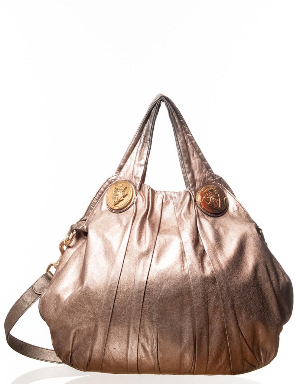 This Gucci Hobo is made of bronzed silver leather with gold crest plates and features a metallic grey exterior and two handles, a small one and a long one. The long one can be removable. 

COLOR: Metallic
MATERIAL: Leather
ITEM CODE: 197016