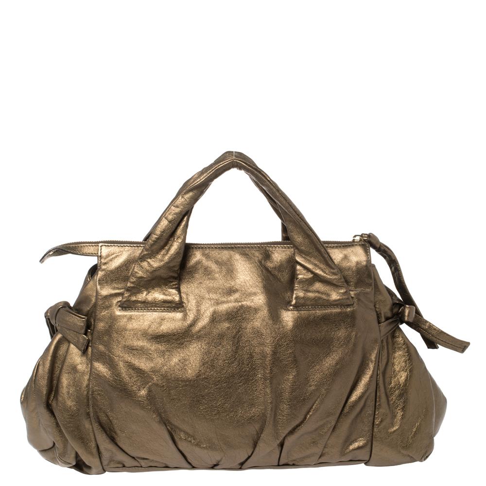 This Gucci Hysteria tote is built for everyday use. Crafted in Italy, it is made from quality leather and comes in a metallic olive green hue. It has ties on the sides and dual handles for you to parade it. The nylon interior is spacious and is