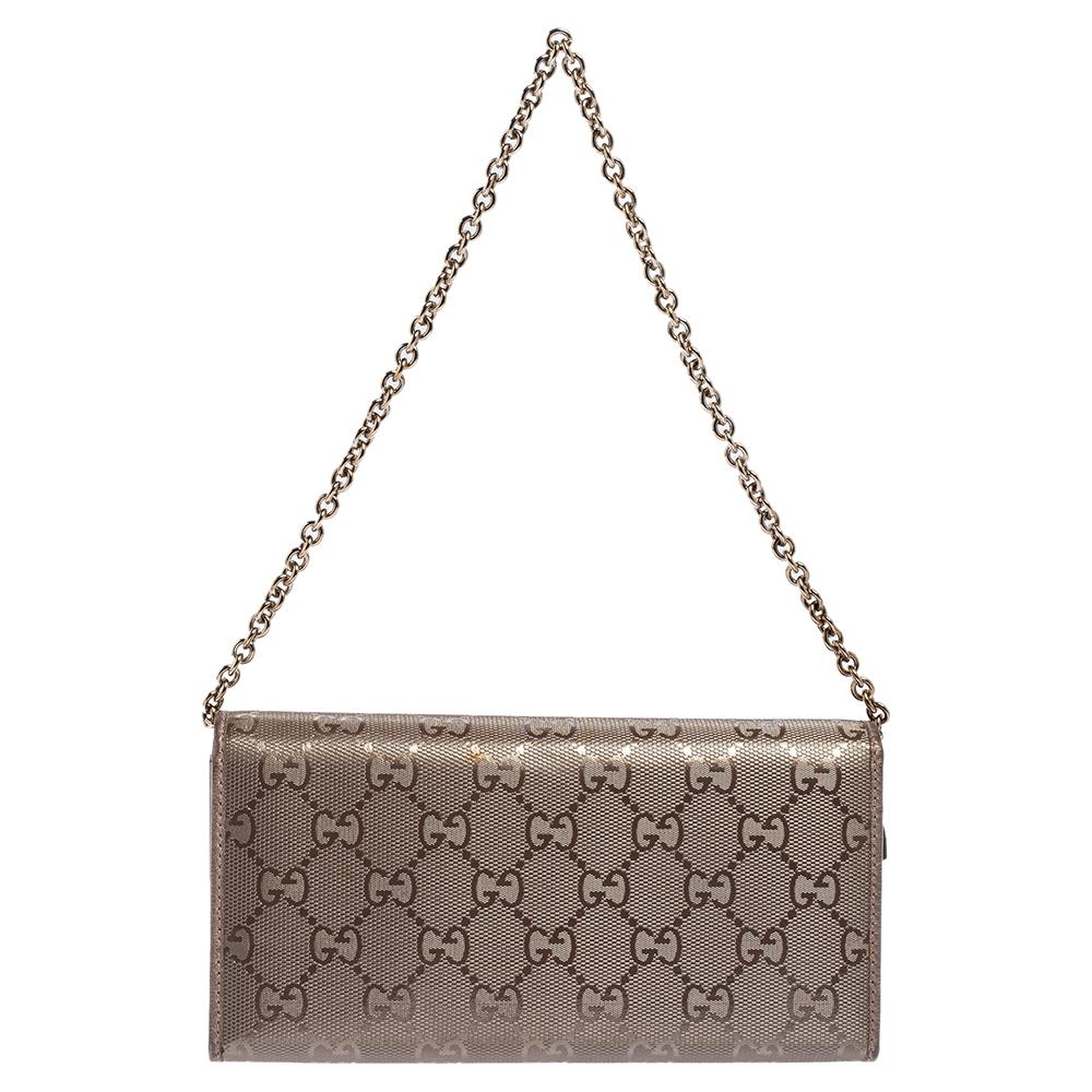 This Gucci wallet on chain clutch is made from GG Imprime canvas and silver-tone hardware. The bag includes a chain-link handle that you can tuck inside to get an evening clutch style. The flap closure opens to a fully organized interior with credit