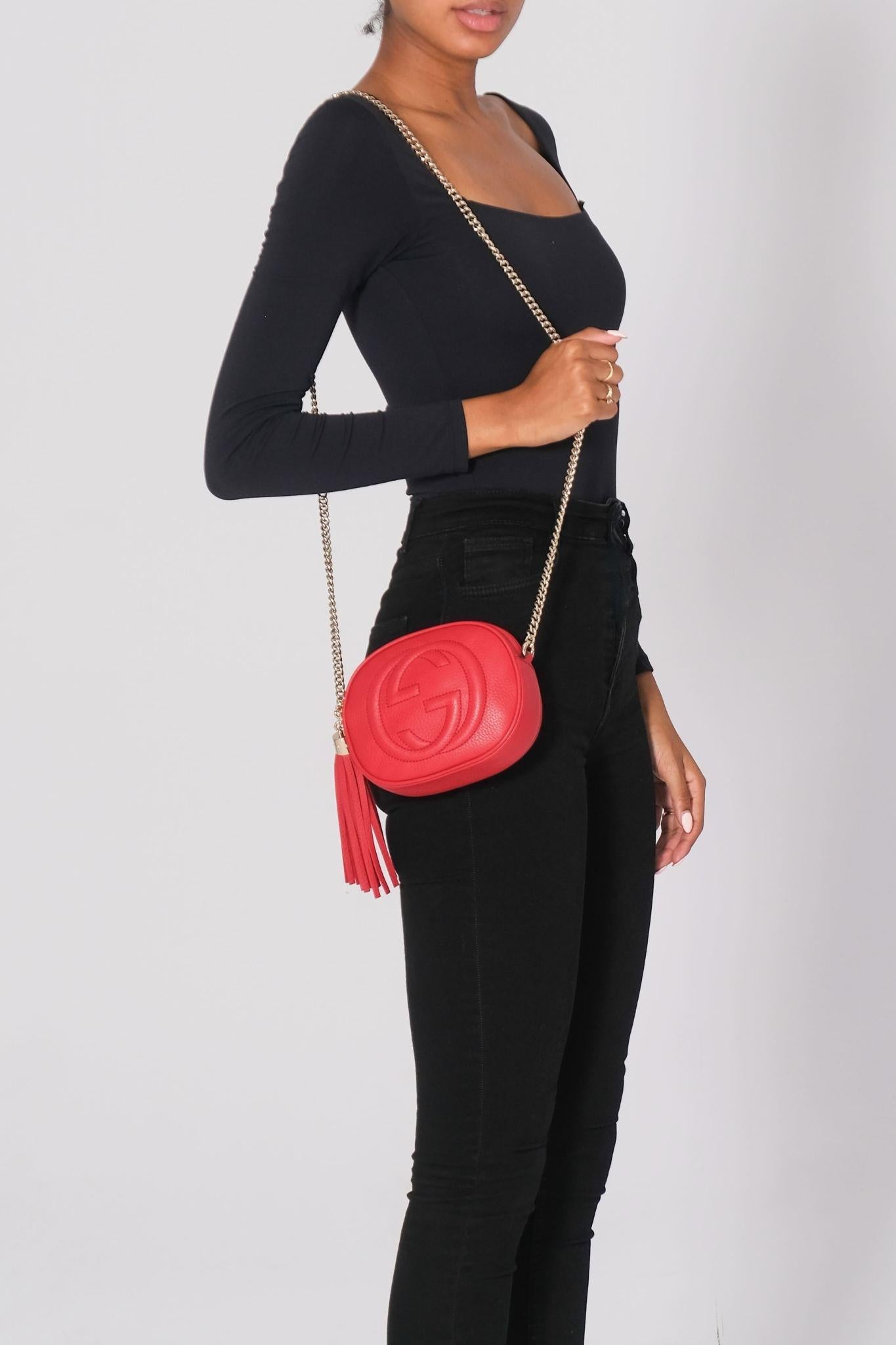 Este bolso crossbody está hecho de piel de becerro roja metalizada, con un prominente logotipo Gucci GG blondie cosido en la parte delantera. El bolso tiene una correa de cadena de eslabones de latón pulido y un tirador de cremallera con borla de