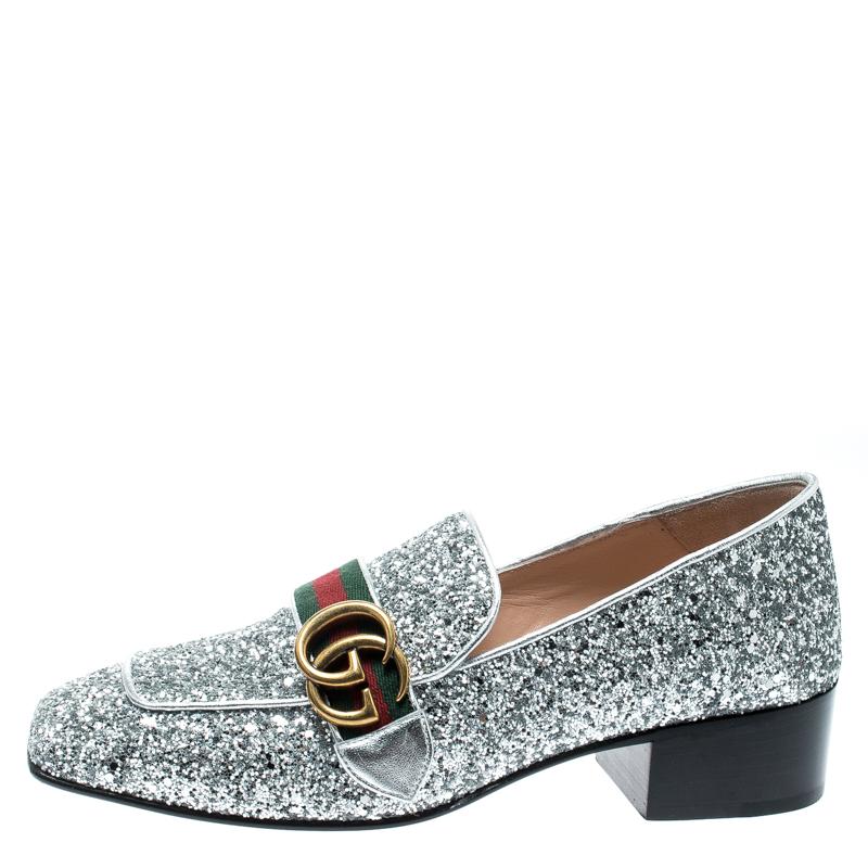Absolutely on-trend and easy to flaunt, this pair of pumps by Gucci is a true stunner. They've been crafted from metallic silver coarse glitter with leather trims and styled with the brand's signature web detail and GG on the uppers. Square toes and