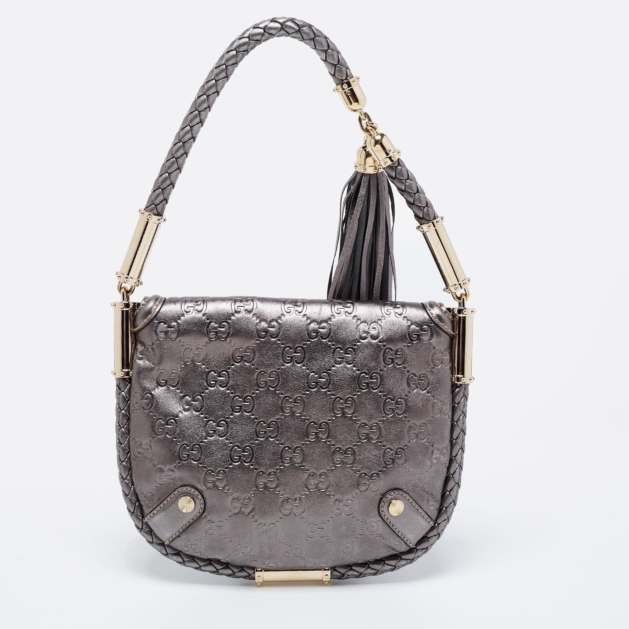 An elegant companion for your outings, this wondrous Britt bag by Gucci is one of its kind. It is made from metallic silver Guccissima leather. The exterior features a braided trim extending to form a short handle with a fringed tassel. The flap