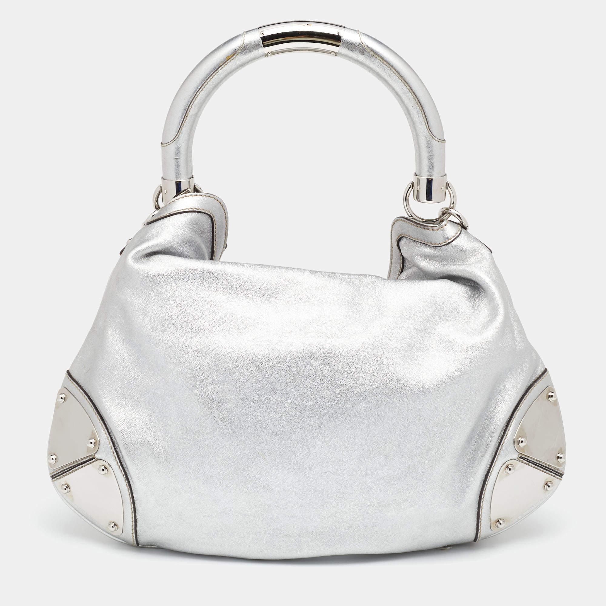 This Gucci Babouska Indy creation might just become the most loved classic bag in your closet. Crafted from metallic silver leather, it has silver-tone metal accents and the signature tassel detail at the front. The bag is equipped with a single