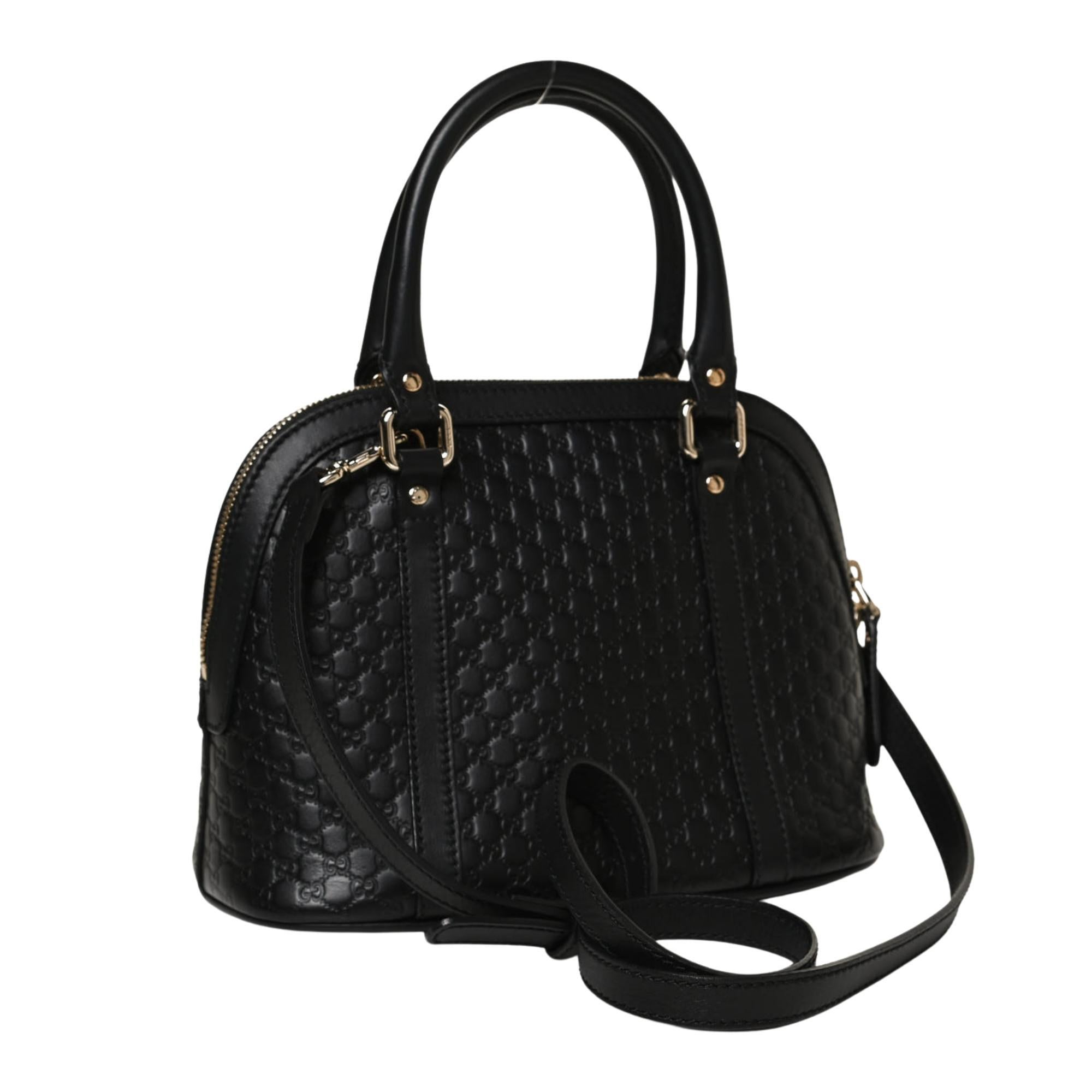 This bag is constructed of embossed microguccissima leather in black. The bag features rolled leather top handles, an optional shoulder strap, and gold hardware. The zipper opens to a spacious beige fabric interior with a patch pocket.

Color: