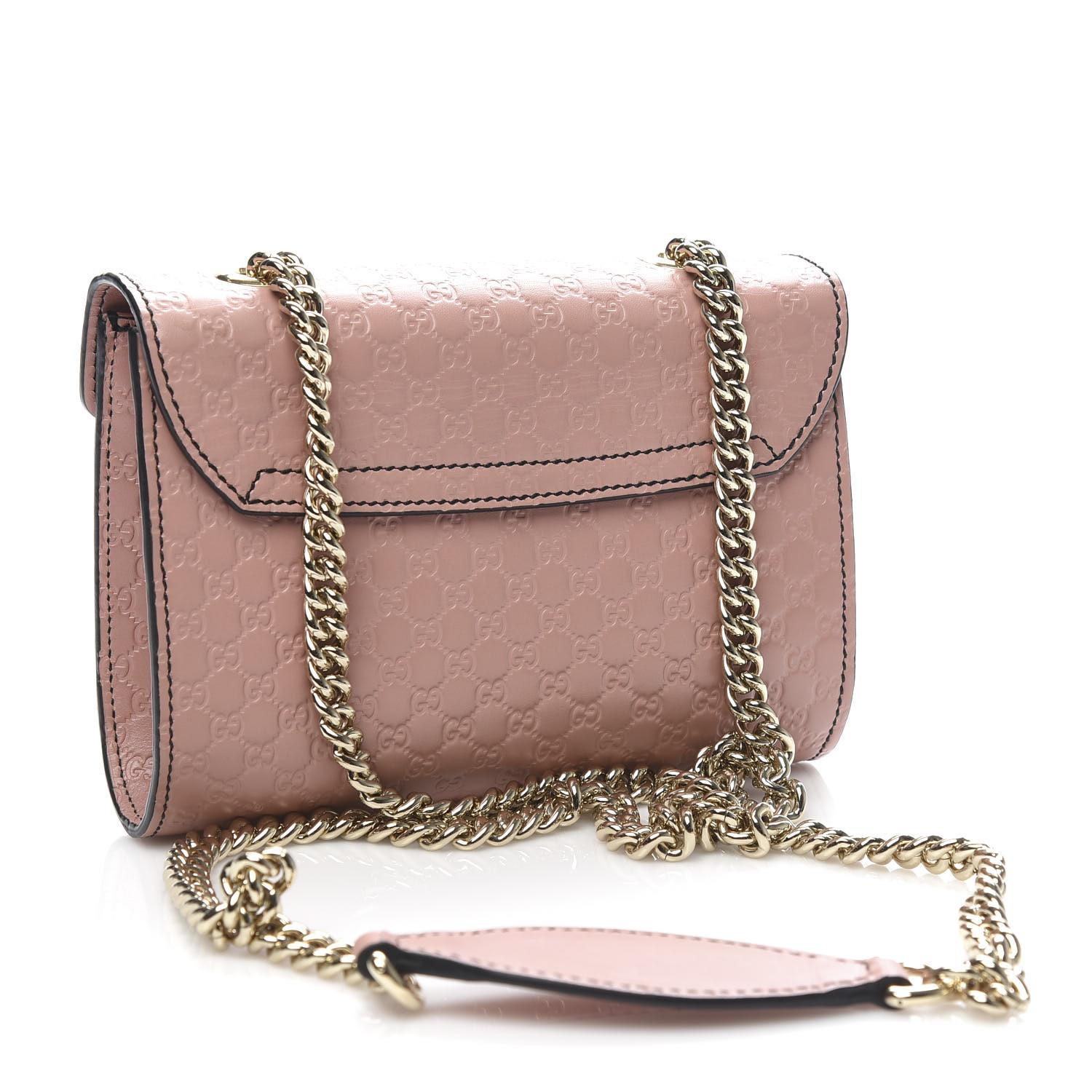 This shoulder bag is made of Gucci GG monogram embossed leather in pink. The handbag features a light gold tone chain link with a leather shoulder pad and a front horse-bit embellishment in light gold that secures the cross-over flap. This opens to