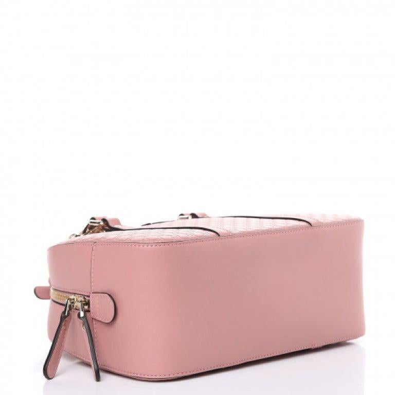 This cross body bag is made with microguccissima embossed leather in soft pink. The bag features dual rolled leather top handles and an adjustable leather shoulder strap with a light gold adjustment buckle. The top zipper opens to a fabric interior