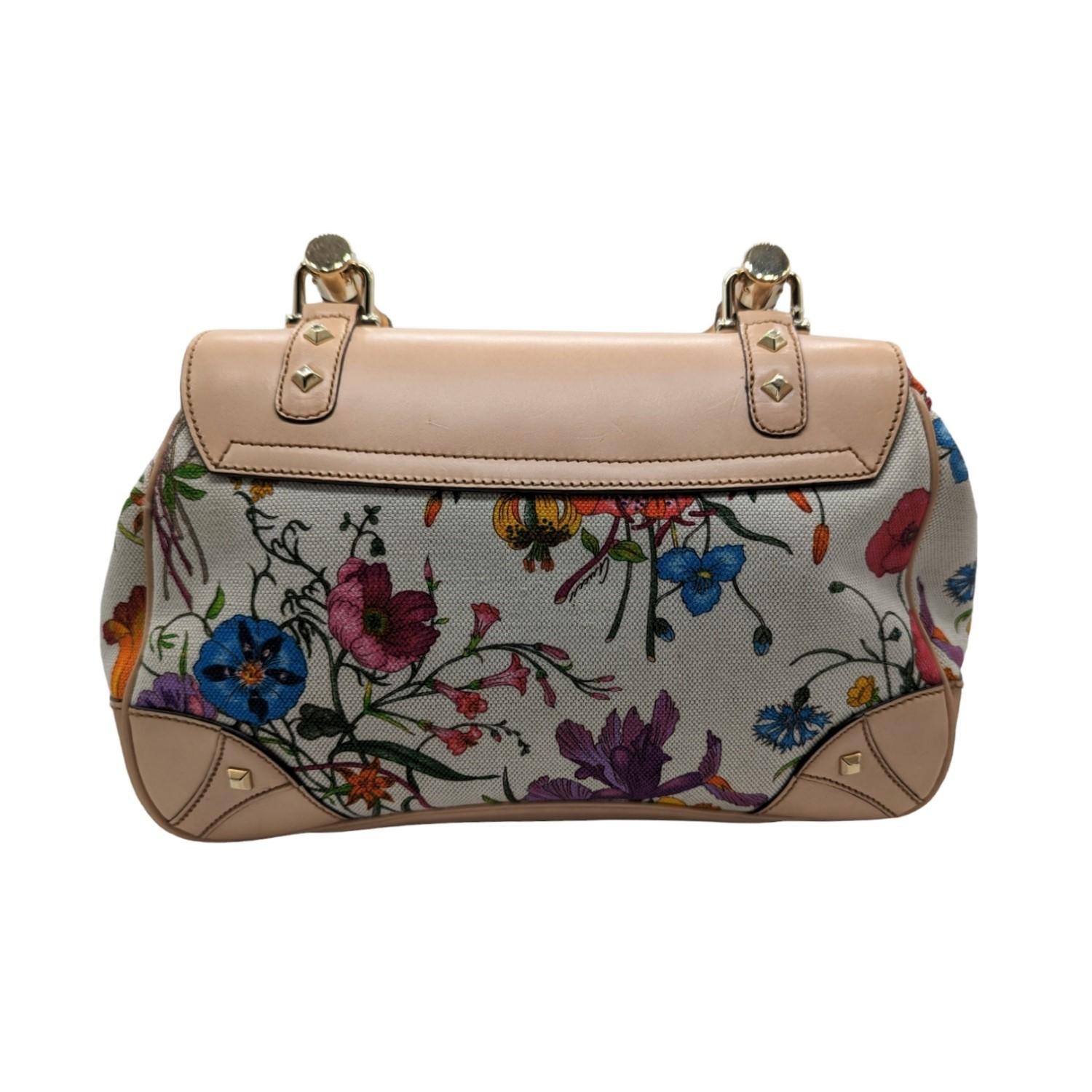 Gucci Canvas Floral Flora Bamboo Handle Bag. This stylish hobo is beautifully crafted of brightly colored wildflower print on a white canvas. The bag features a natural bamboo handle and polished brass hardware. Front flap bamboo turn-lock opens to