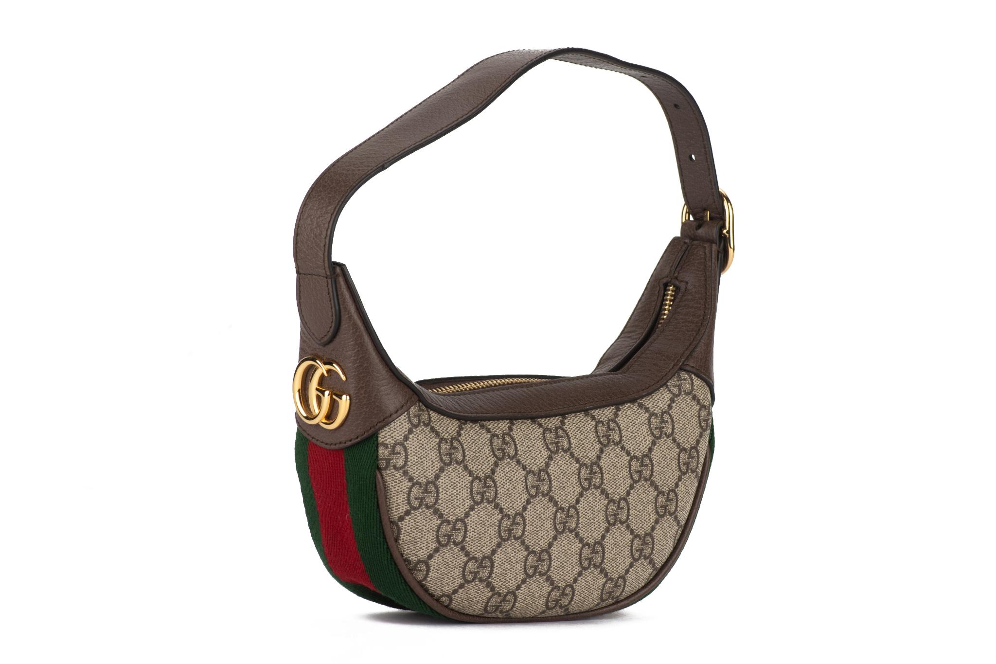 Gucci mini Ophidia Halbmond-Tasche mit klassischem GG Canvas-Druck, braunem Lederbesatz und goldfarbener Hardware. Perfektes Äußeres, minimale Abnutzung im Inneren. 
Verstellbarer Schultergurt mit einer Tiefe von 6