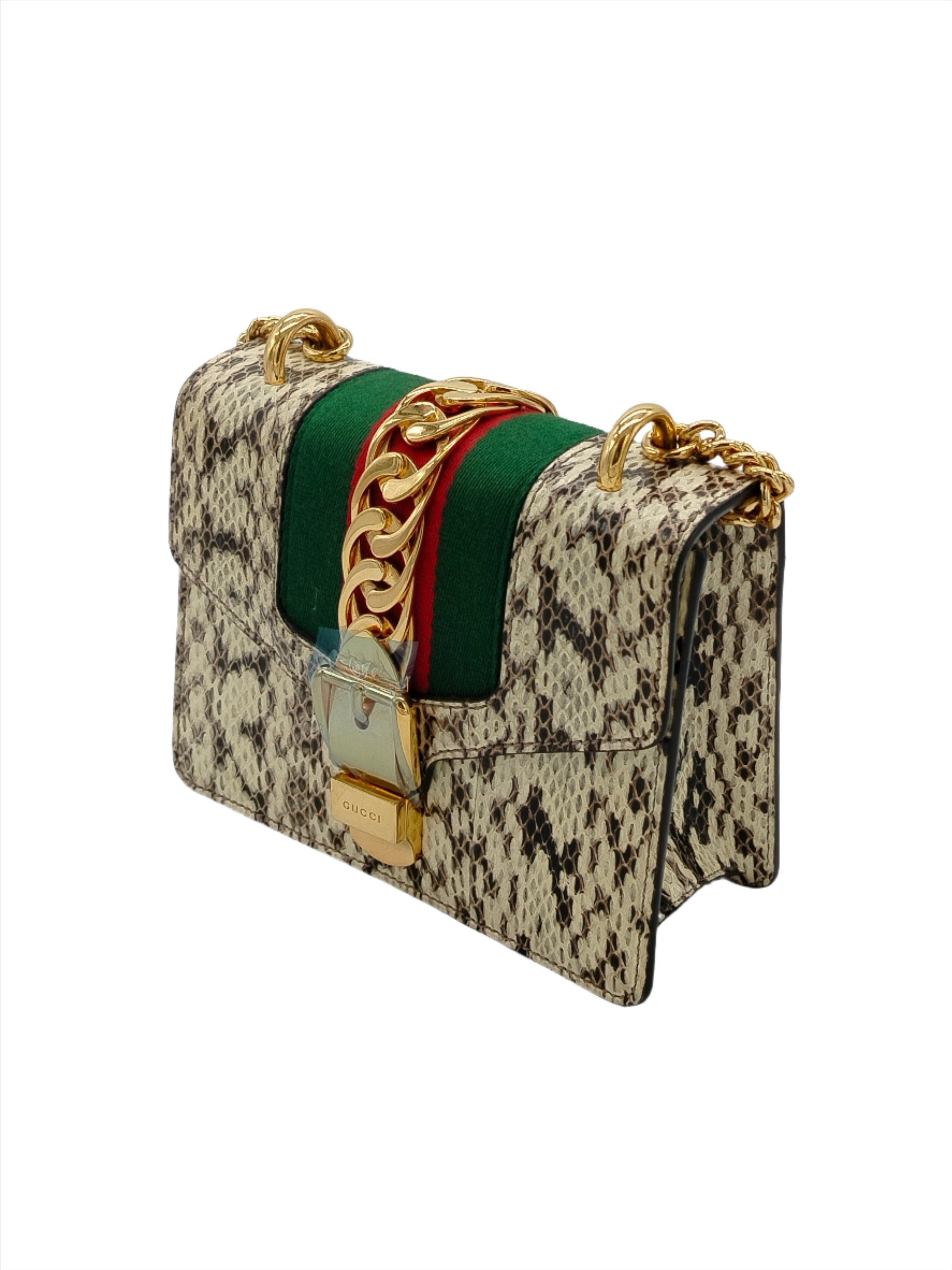 White Gucci Mini Sylvie bag. The Sylvie features a leather body, flat leather handles, detachable shoulder strap, front flap with push-lock closure, and interior slit pockets.
Inclusion: dust bag.

Height:13;Width:17;Depth:7;Handle Drop:50 Material: