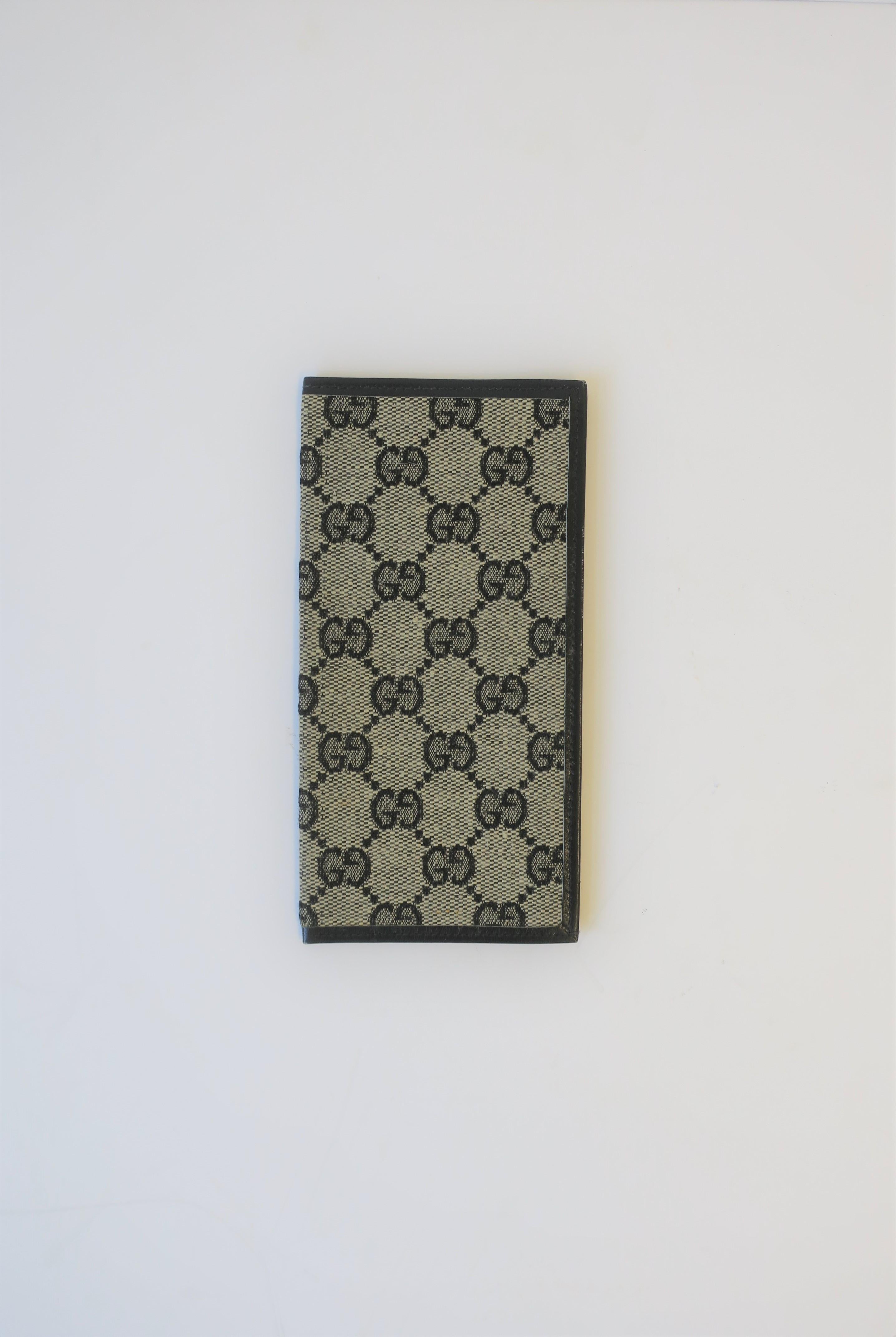 From luxury marker Gucci, a dark blue leather and iconic Gucci canvas money bill holder wallet, circa late 20th century, Italy. Marked 