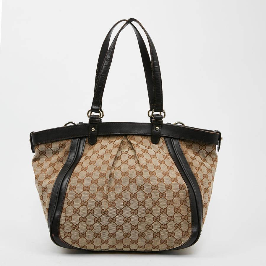 This GUCCI tote in brown monogram canvas comes from the Bambou collection. The outline of the bag is in brown leather. It is worn on the shoulder with its double leather handle. On the front of the bag two bamboo loops. The interior is in white