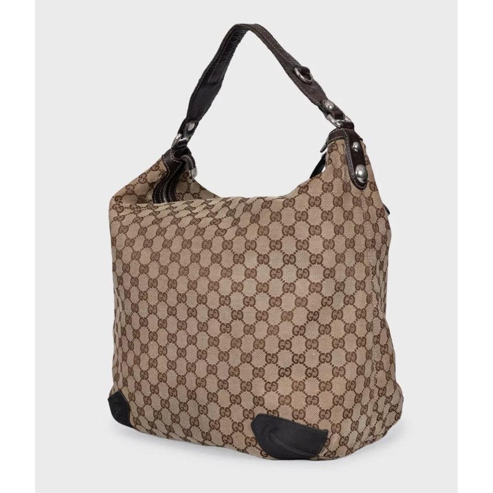 Sac hobo intemporel de Gucci, confectionné en Italie de manière experte à partir d'une combinaison de cuir véritable et de la toile emblématique du monogramme GG. Cet élégant sac est doté d'une confortable bandoulière en cuir, d'une fermeture à