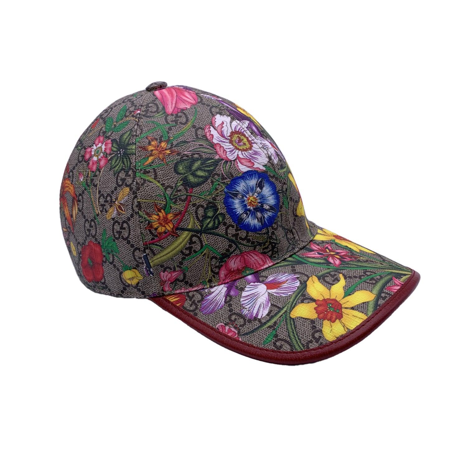Casquette de baseball en toile GG Flora avec monogramme beige, signée Gucci. Garniture en cuir rouge. Doublure en coton. Il est doté d'une visière incurvée et d'une coupe ajustable. Composition : 56% Polyester, 44% Coton. Taille : M - 57 mm.