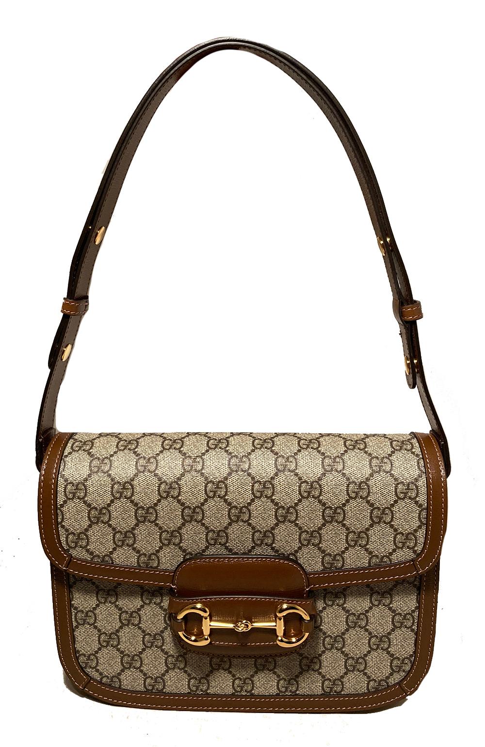 Gucci Monogram Horsebit 1955 Shoulder Bag in NWOT condition. Signature monogram canvas exterior trimmed with brown leather and gold hardware. Timeless horsebit hardware along front closure. Top flap opens to a beige suede lined interior with 3