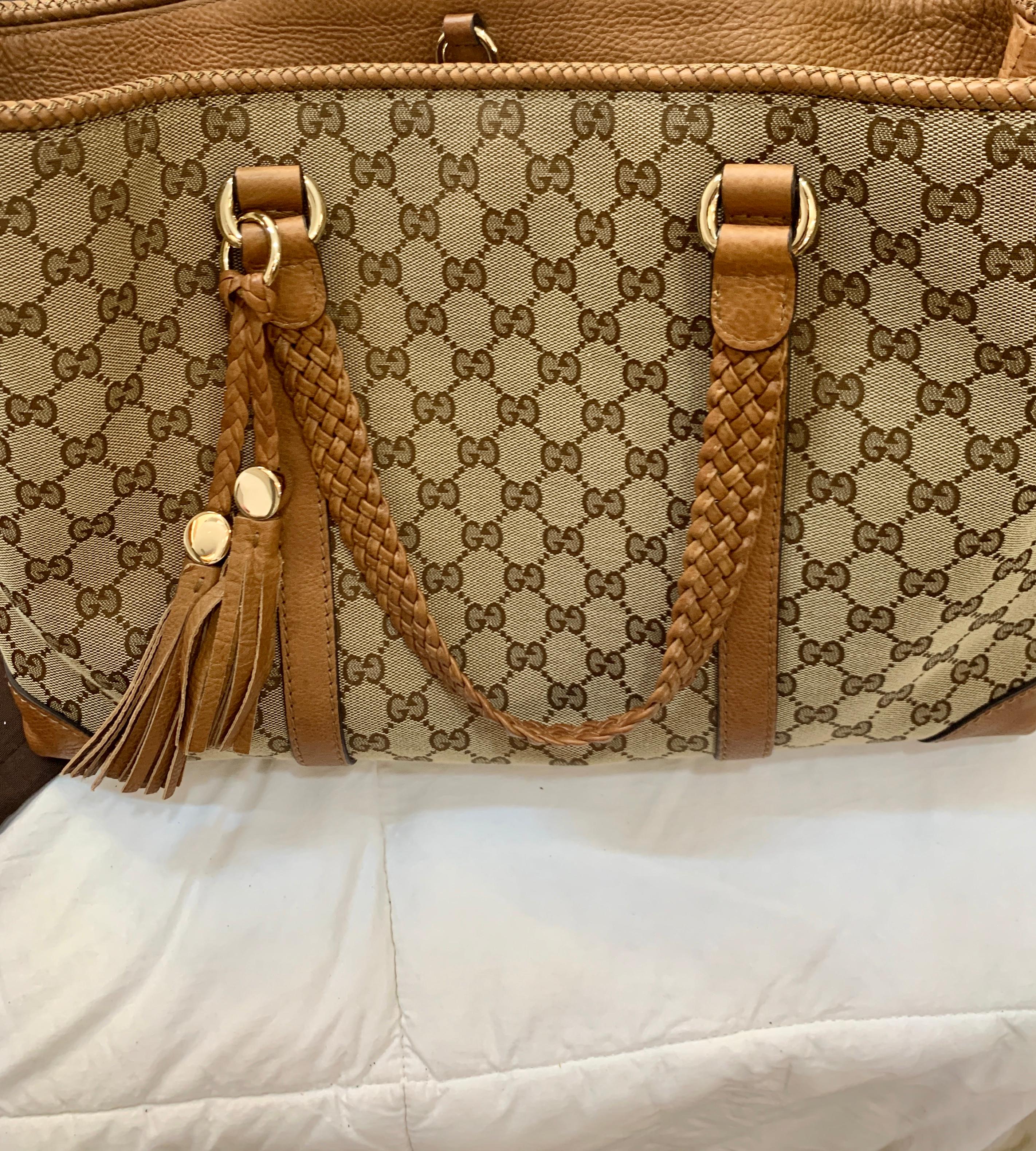 This is an authentic GUCCI Monogram Large Original Tote Tan . This chic tote is crafted of traditional brown on beige Gucci GG monogram canvas. The bag features light brown  leather details including strap top handles and corner reinforcements. The