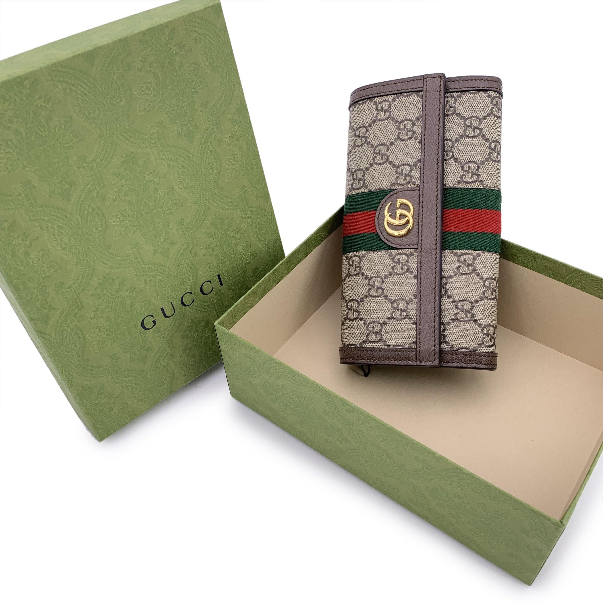 There's a timeless elegance to the Gucci 'Ophidia' line, and this flap continental wallet captures it perfectly. Crafted in beige GG Supreme monogram canvas and framed with crisp white leather trim, this piece speaks to the house's heritage with a