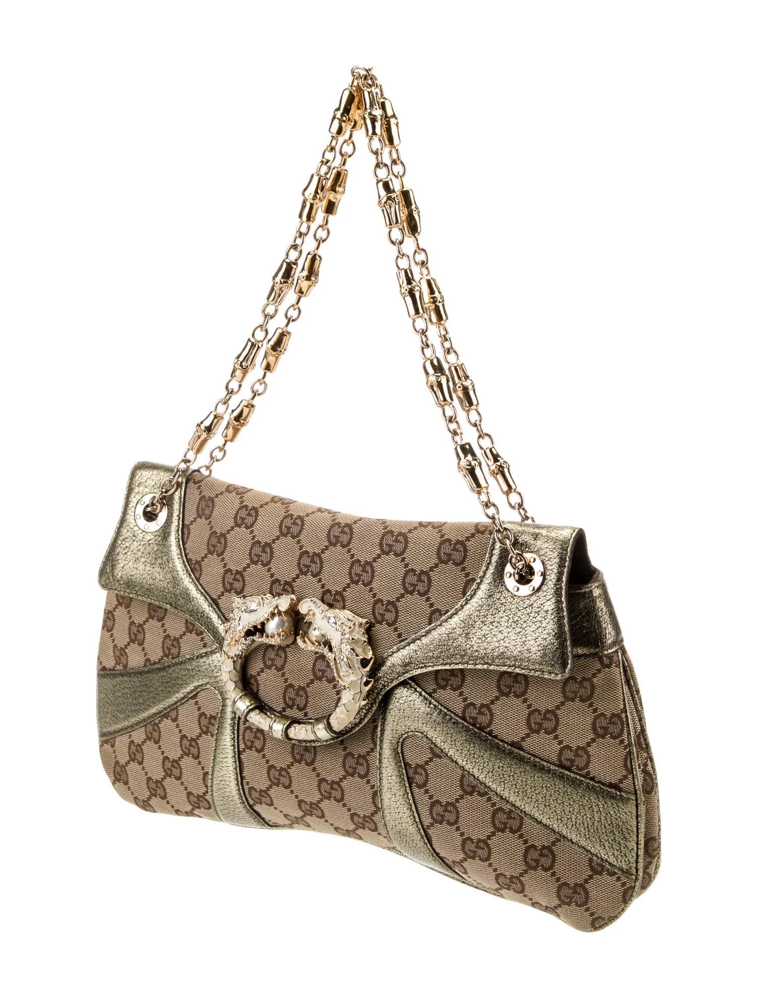 This is a rare bag with sophisticated design and innovative features. The bag is made out of the classic GG monogram canvas with extensive metallic gold leather trim. At the front flap is a dragon detail with Swarovski crystals and faux pearls. The